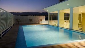 A swimming pool on a deck with a view of mountains in the background. - Urbana Class Hotel (Mendoza)