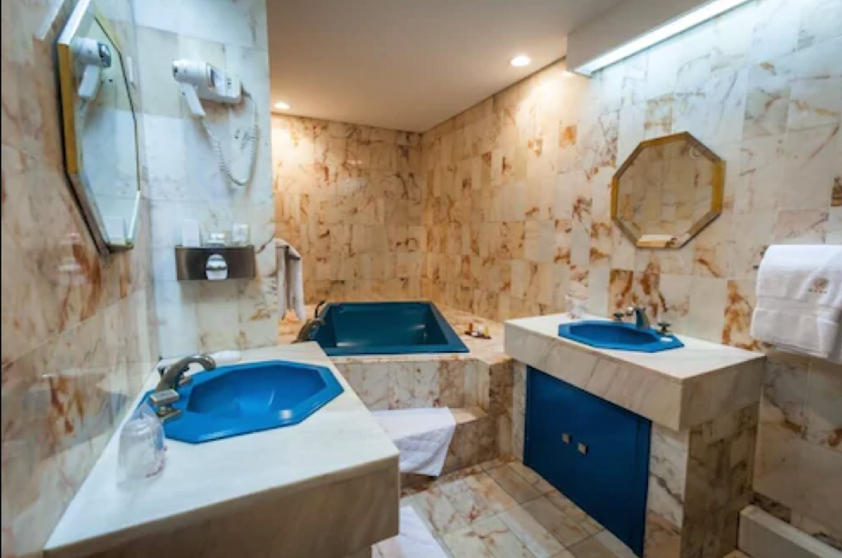 A bathroom with two sinks, a bathtub, and a mirror.