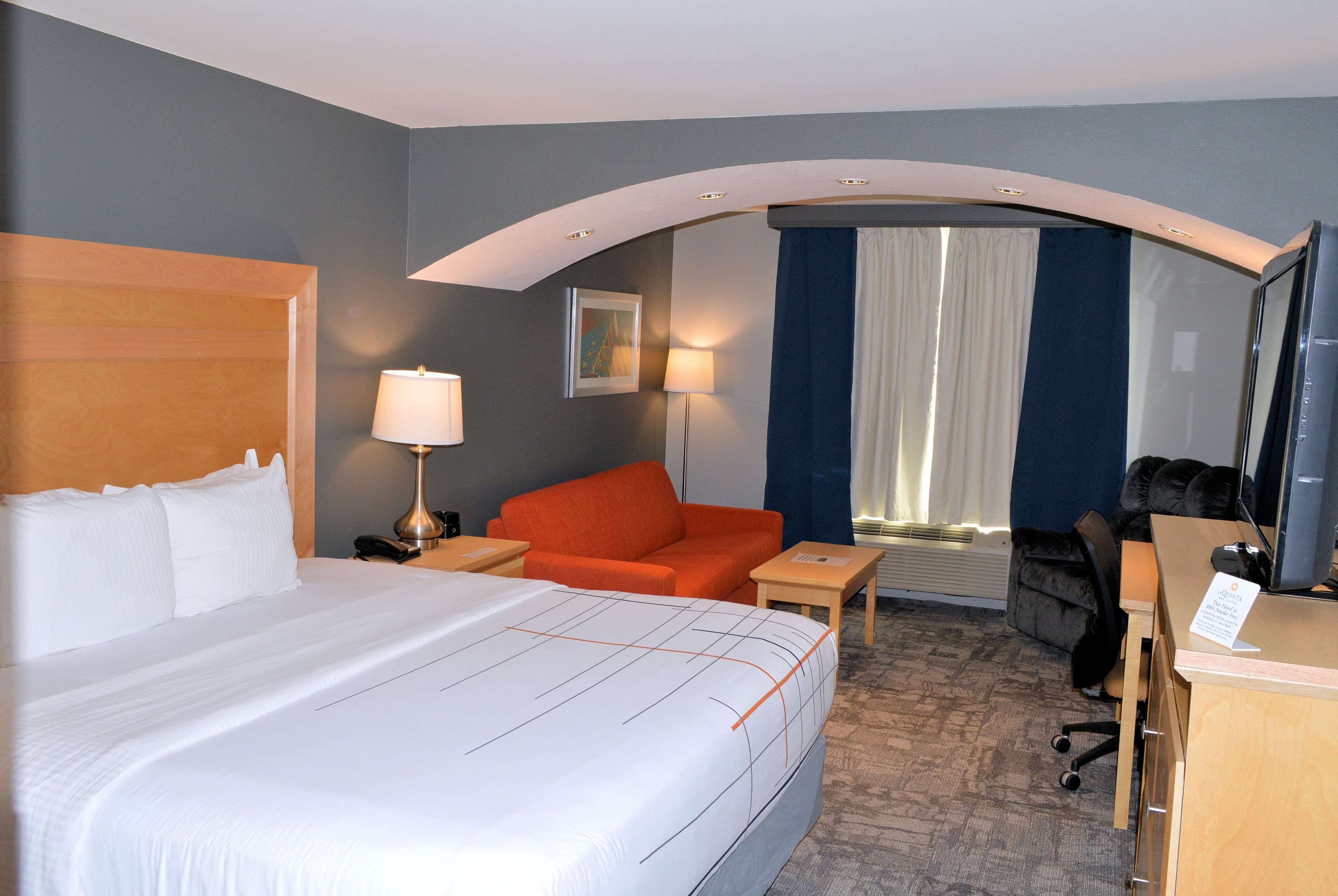 Een hotelkamer met een groot bed, een bureau, een stoel en een bank.
