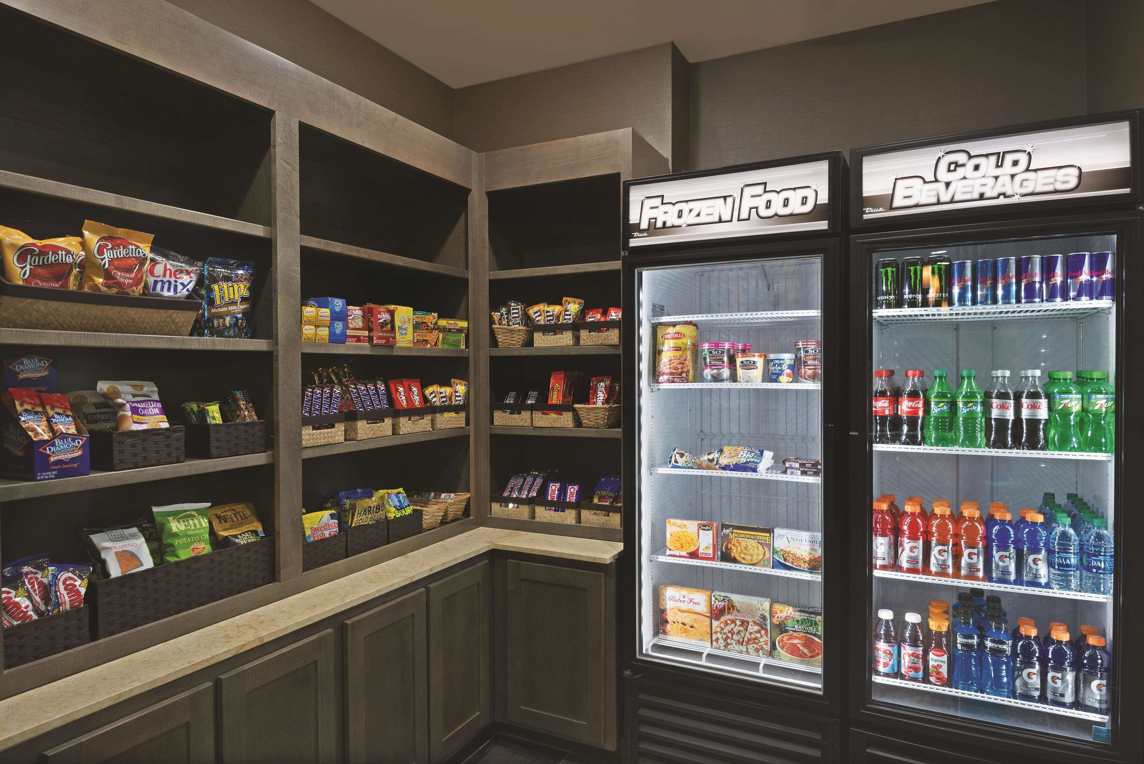 Un espace de vente proposant des collations et des boissons, avec des sections clairement indiquées pour les aliments surgelés et les boissons froides.