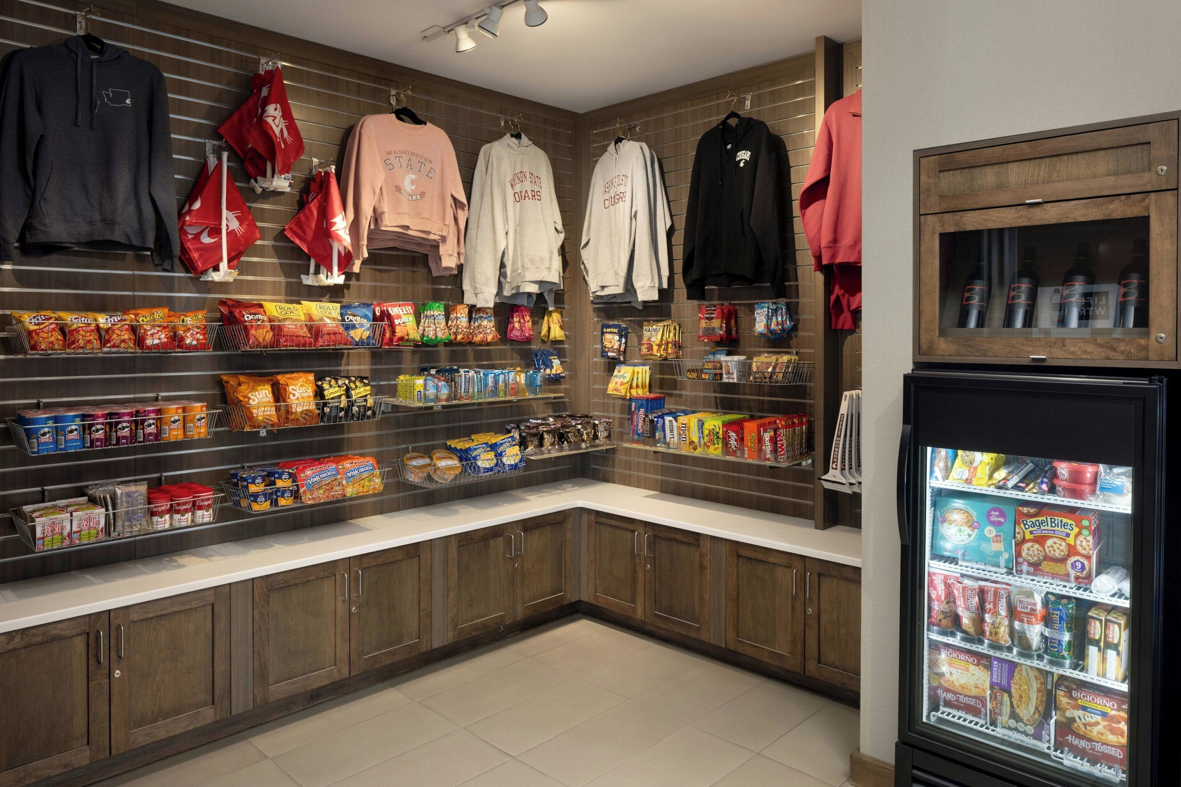 A snack and clothing display area with shelves of snacks and hanging clothes.