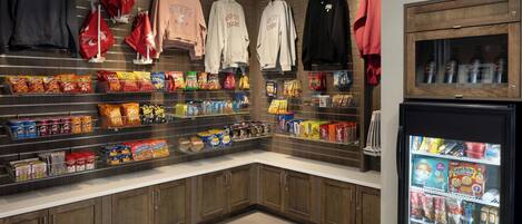 A snack and clothing display area with shelves of snacks and hanging clothes.