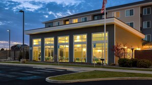 A modern hotel with large windows, a flag, and a parking lot. - Residence Inn Pullman (Pullman)