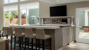 A modern kitchen with a bar area, large windows, and a flat-screen TV. - Residence Inn Pullman (Pullman)