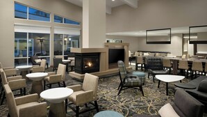 A spacious lobby with a fireplace, comfortable seating, and large windows. - Residence Inn Pullman (Pullman)
