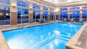 A swimming pool with clear blue water, surrounded by large windows offering views of the outside. - Residence Inn Pullman (Pullman)