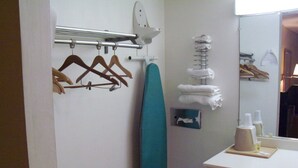 A bathroom with a towel rack, a hanging towel rack, a mirror, and a shelf with toiletries. - Rodeway Inn South Point (South Point)