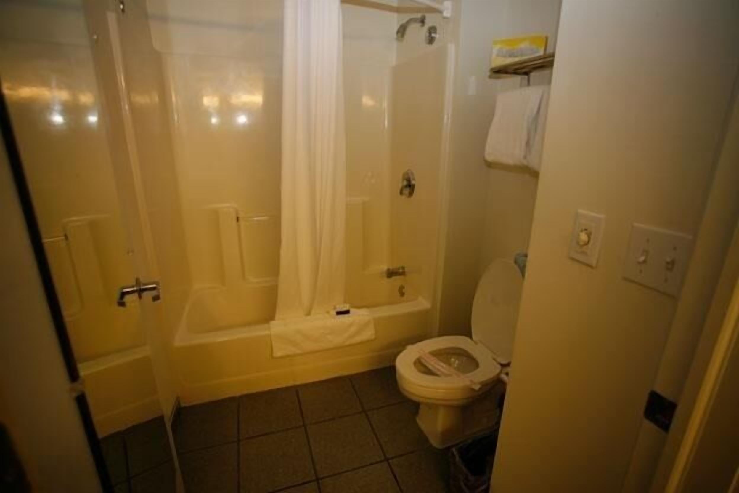 Un baño con bañera, ducha e inodoro.