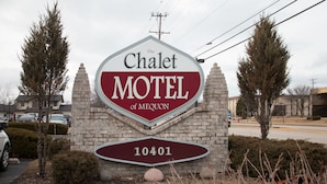 Une enseigne pour le Chalet Motel de Mequon, avec le nom du motel bien en évidence et le numéro « 10401 » en grand.