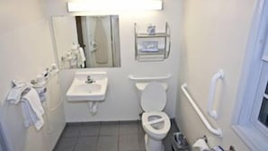 Une petite salle de bain compacte, équipée d’un lavabo, de toilettes et d’un miroir.