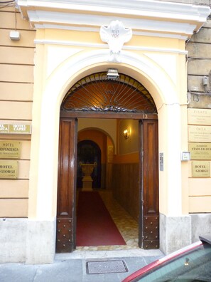 A hotel entrance with a red carpet, a metal gate, and signs indicating room availability. - Hotel Giamaica for Girls & Ladies Only (Rome)