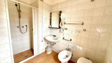 Un bagno con doccia, due lavandini, un bidet e il water.