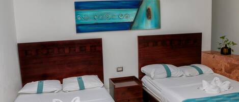 A hotel room with two beds, a wooden headboard, a small wooden nightstand, and a painting on the wall.
