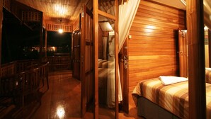 Eine Holzhütte mit Bett, Treppe und Balkon.