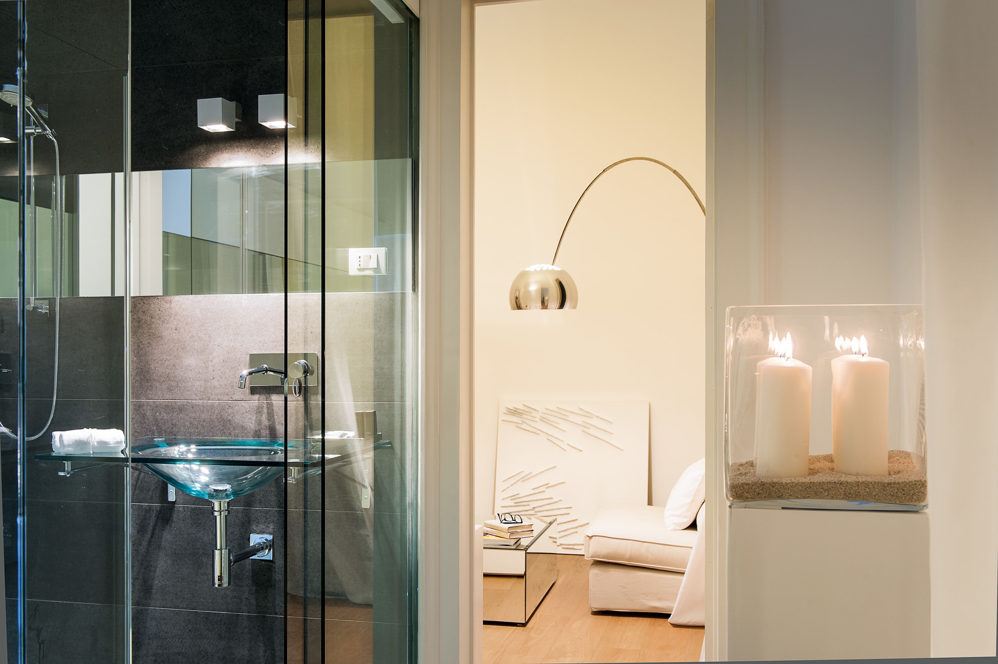 A modern bathroom with a glass sink, a shower, and a minimalist design.