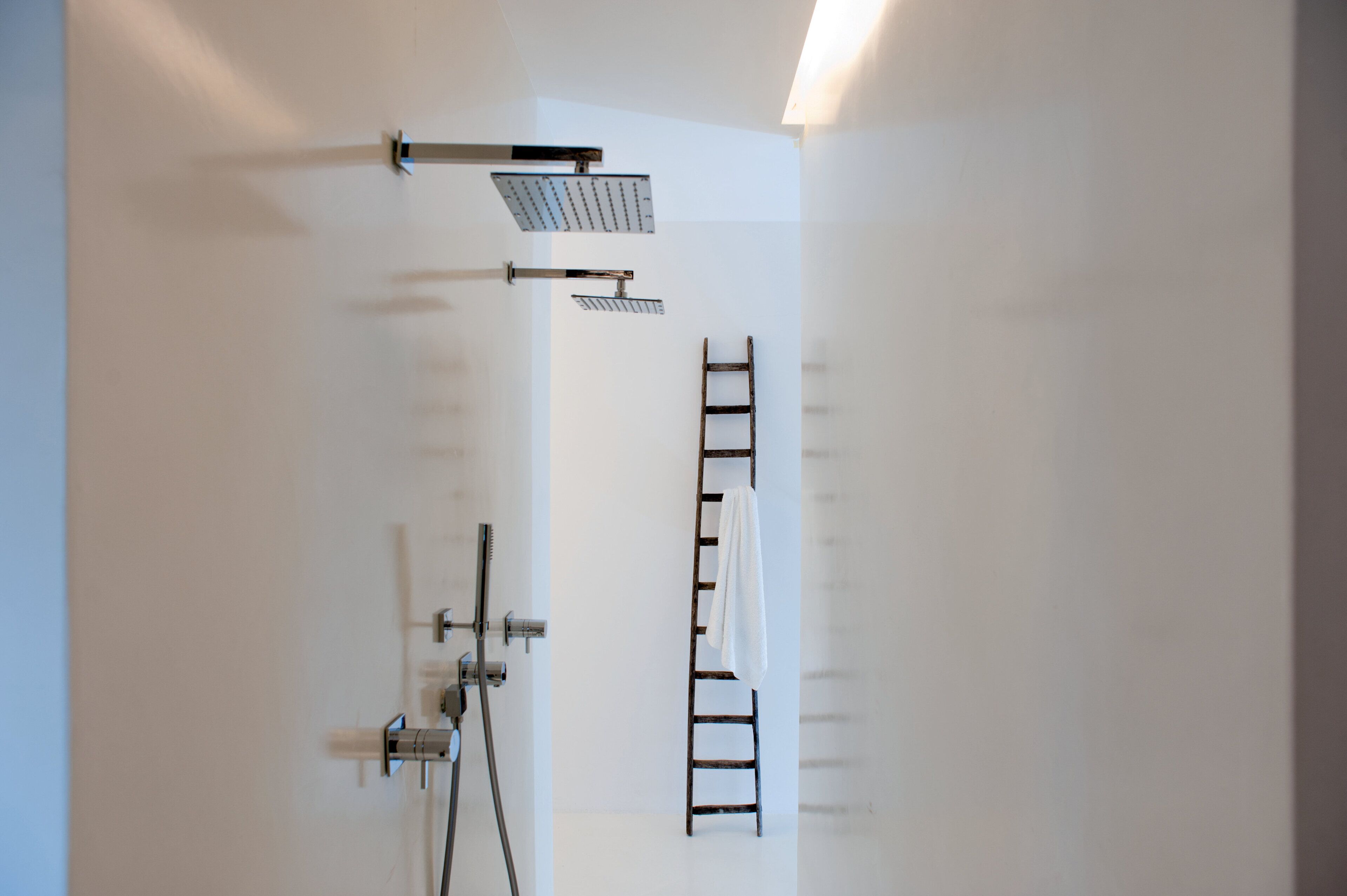 Un baño moderno con ducha, toallero y una escalera.