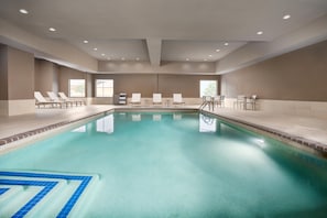 An indoor swimming pool with lounge chairs and tables, large windows, and a tiled floor. - Homewood Suites by Hilton Midland, TX (Midland)