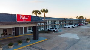 A Red Roof Inn with a parking lot and several parked cars.