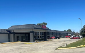 A Red Roof Inn with a modern design, featuring a flat roof and a parking lot with several cars. - Red Roof Inn Slidell  (Slidell)