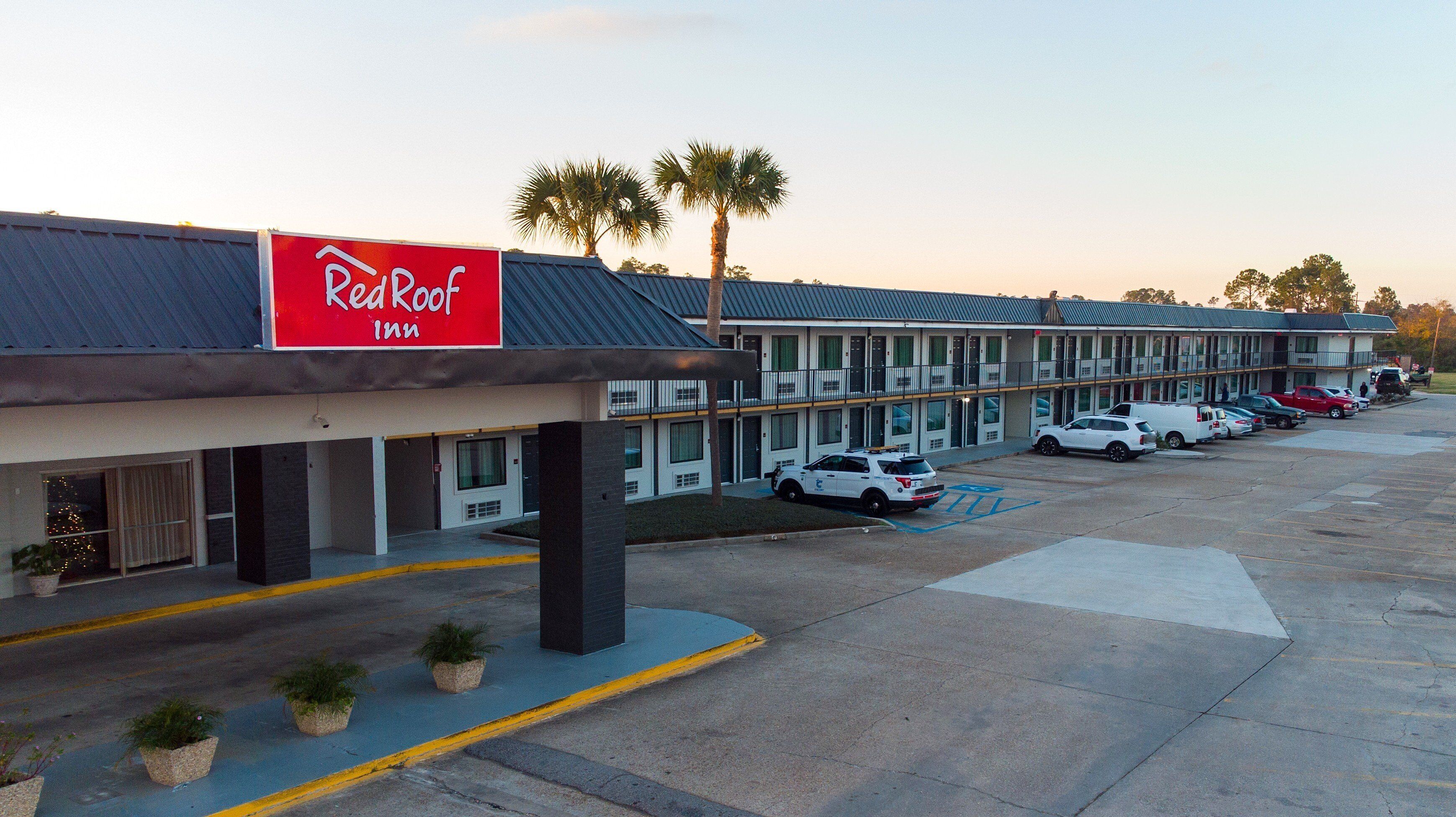 Ein Red Roof Inn mit Parkplatz und mehreren parkenden Autos.