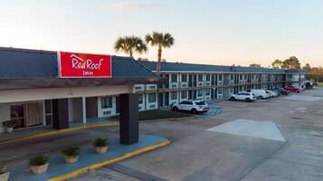 Un hotel Red Roof Inn con un estacionamiento y varios automóviles estacionados.
