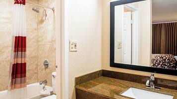 Ein Badezimmer mit einer Badewanne, Toilette und einem Waschbecken mit Granitplatte.