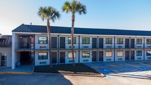 A multi-story motel with a flat roof, large windows, and a parking lot with handicapped parking. - Red Roof Inn Slidell  (Slidell)
