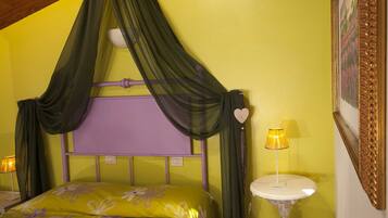 Une chambre à coucher avec un lit, une table de chevet, une lampe et un cadre photo fixé au mur.