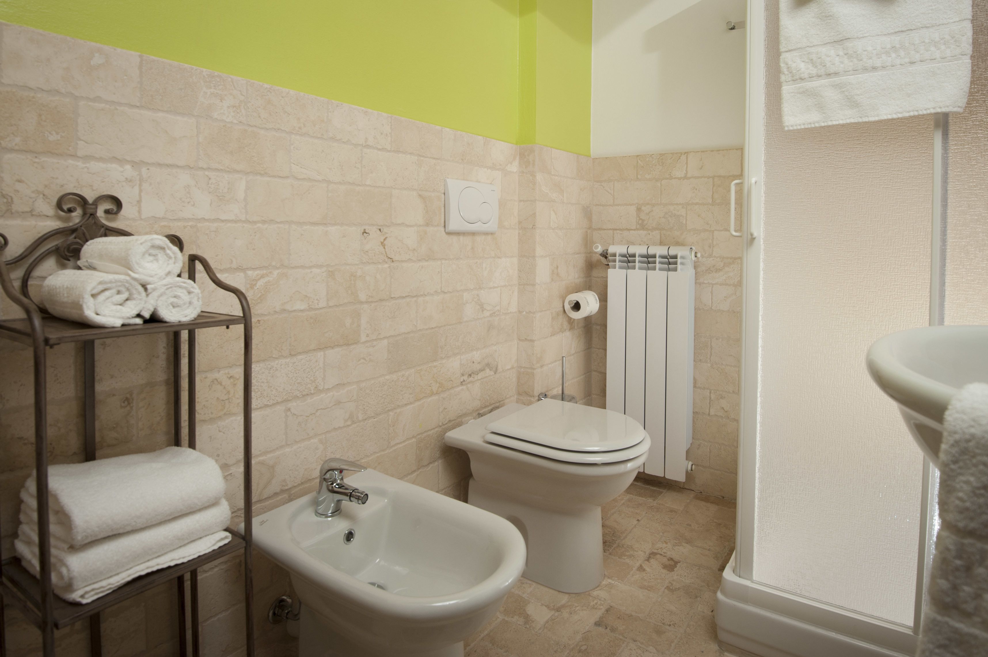 Een badkamer met een bidet, toilet en een handdoekhouder.