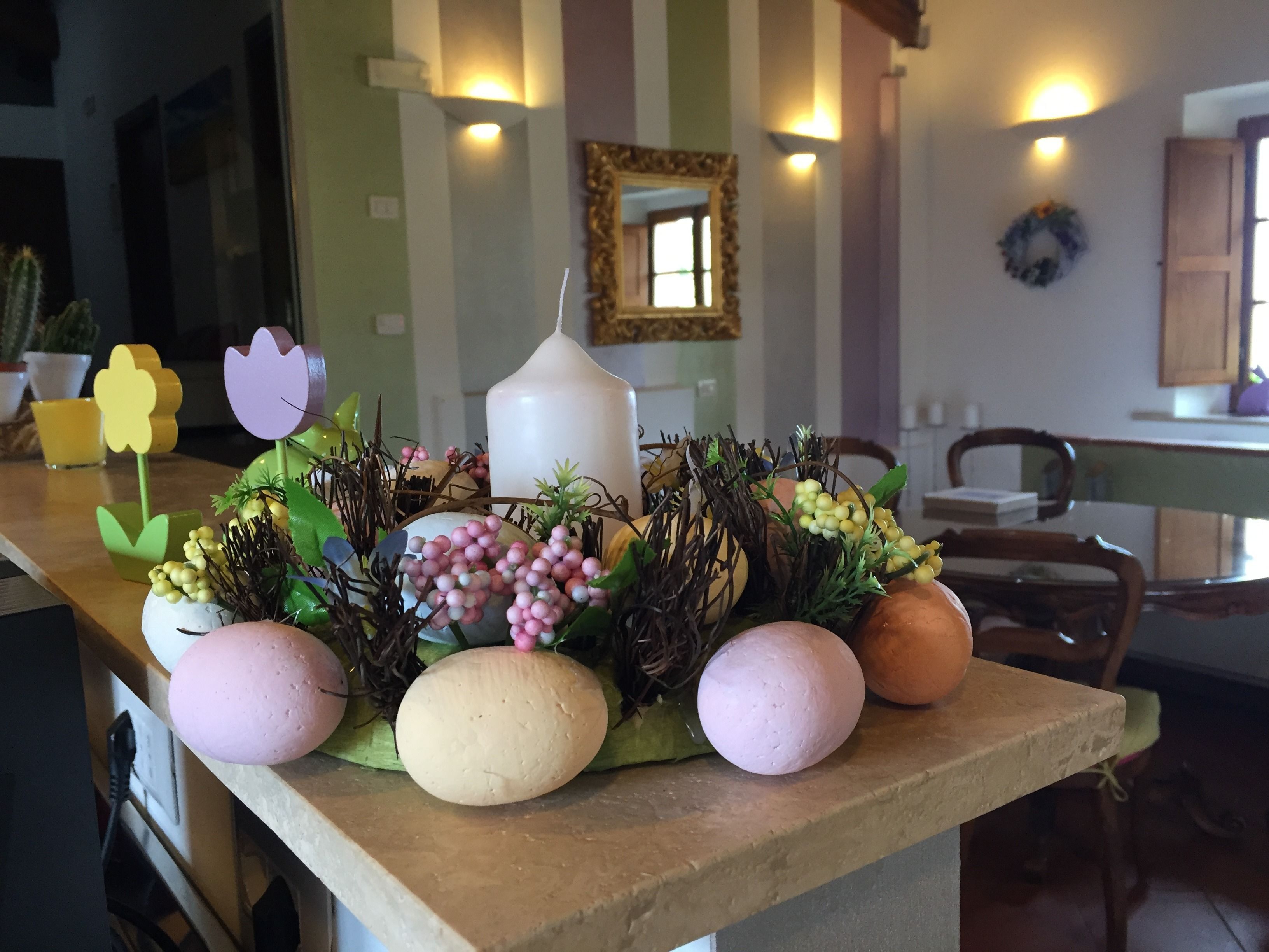 A kitchen counter with a decorative arrangement of eggs, flowers, and greenery.