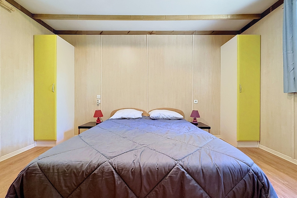 Une chambre à coucher avec un grand lit, deux tables de chevet et un plafond en bois.