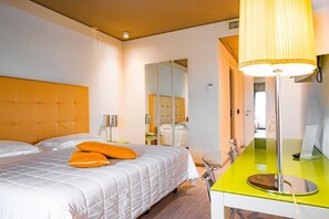 A hotel room with a large bed, a bedside table, a mirror, and a bright lamp. - One Hotel & Restaurant (Dalmine)