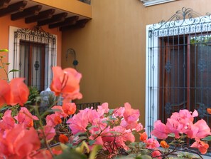 A building with a wrought iron gate, a balcony with wooden beams, and a wall-mounted light fixture. - Hotel Boutique Parador San Miguel (Oaxaca)