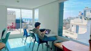 A spacious room with a large window offering a view of the cityscape. - Viajero Montevideo Hostel (Montevideo)