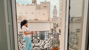 A balcony with a tiled floor, a potted plant, and a railing. - Viajero Montevideo Hostel (Montevideo)