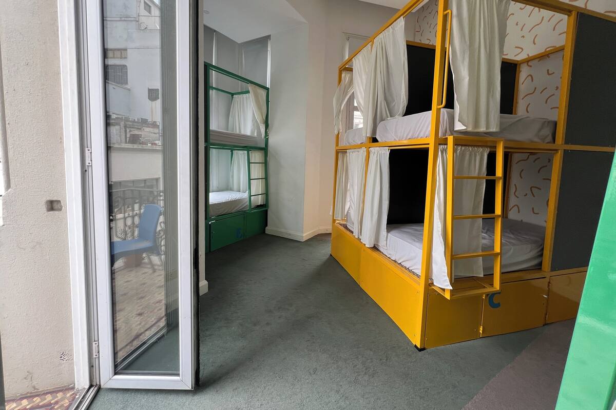 A room with bunk beds, a sliding door, and a view of the outside.