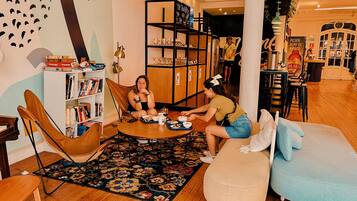Una sala de estar acogedora con una mesa redonda, una estantería y un sofá.