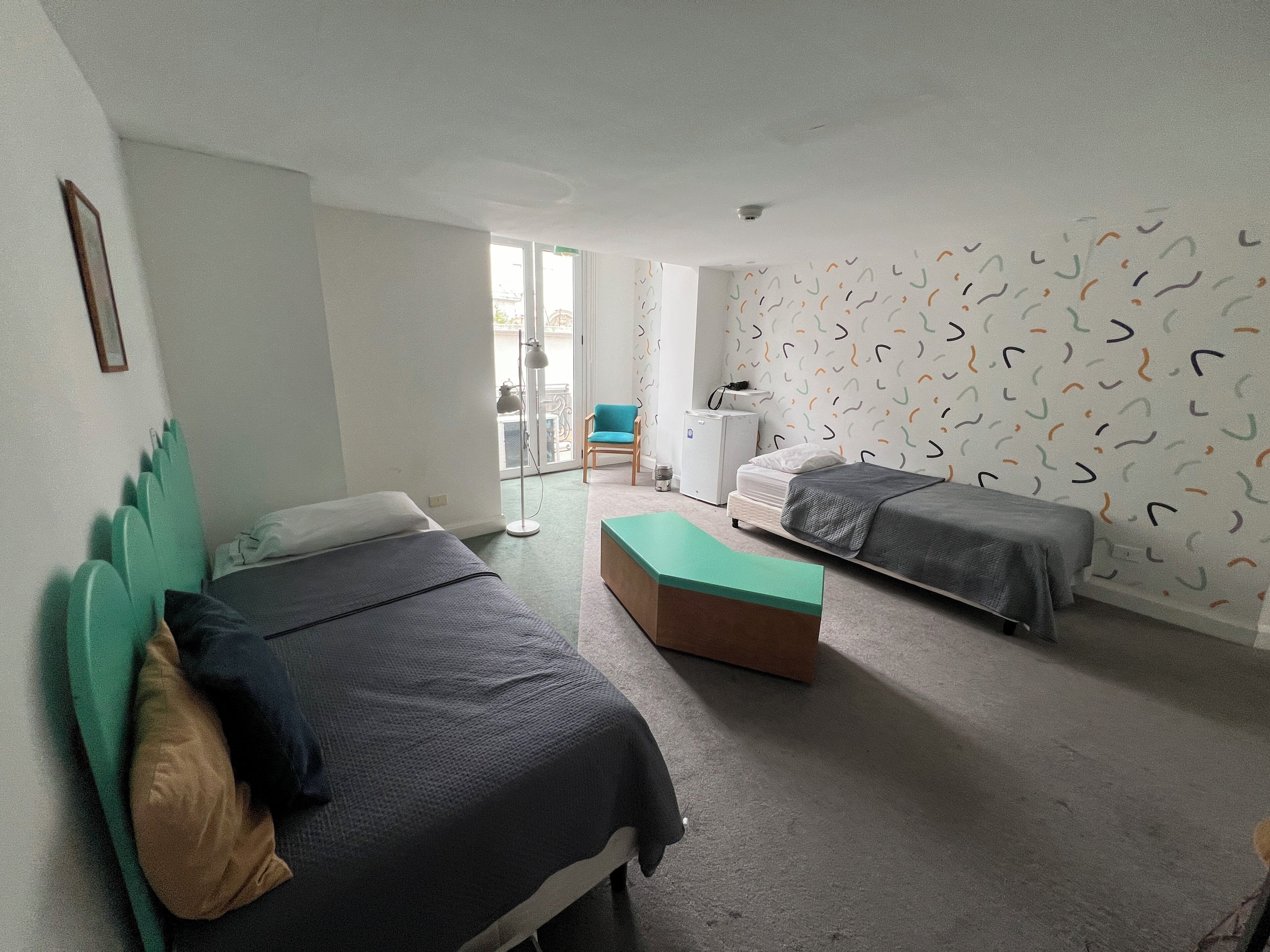 Un dormitorio con dos camas, un escritorio y una silla.