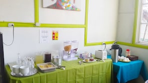 A buffet setup with various food items and a sign requesting guests to clean up. - Hotel de La Cuesta (San José)