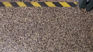 Escada com marcações de segurança em amarelo e preto que dá acesso a um nível inferior.