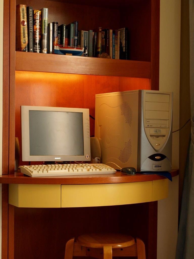 A computer desk with a desktop computer, keyboard, and mouse.