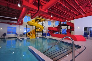 Una piscina interior con varias toboganes y zona de piscina despejada.