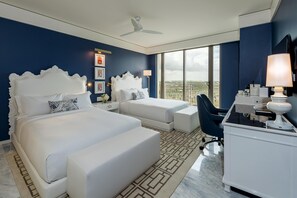 Une chambre d’hôtel avec un grand lit, un bureau, une chaise et une vue sur la ville.