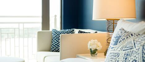 A hotel room with a bed, a nightstand, a lamp, and a view of the outdoors.