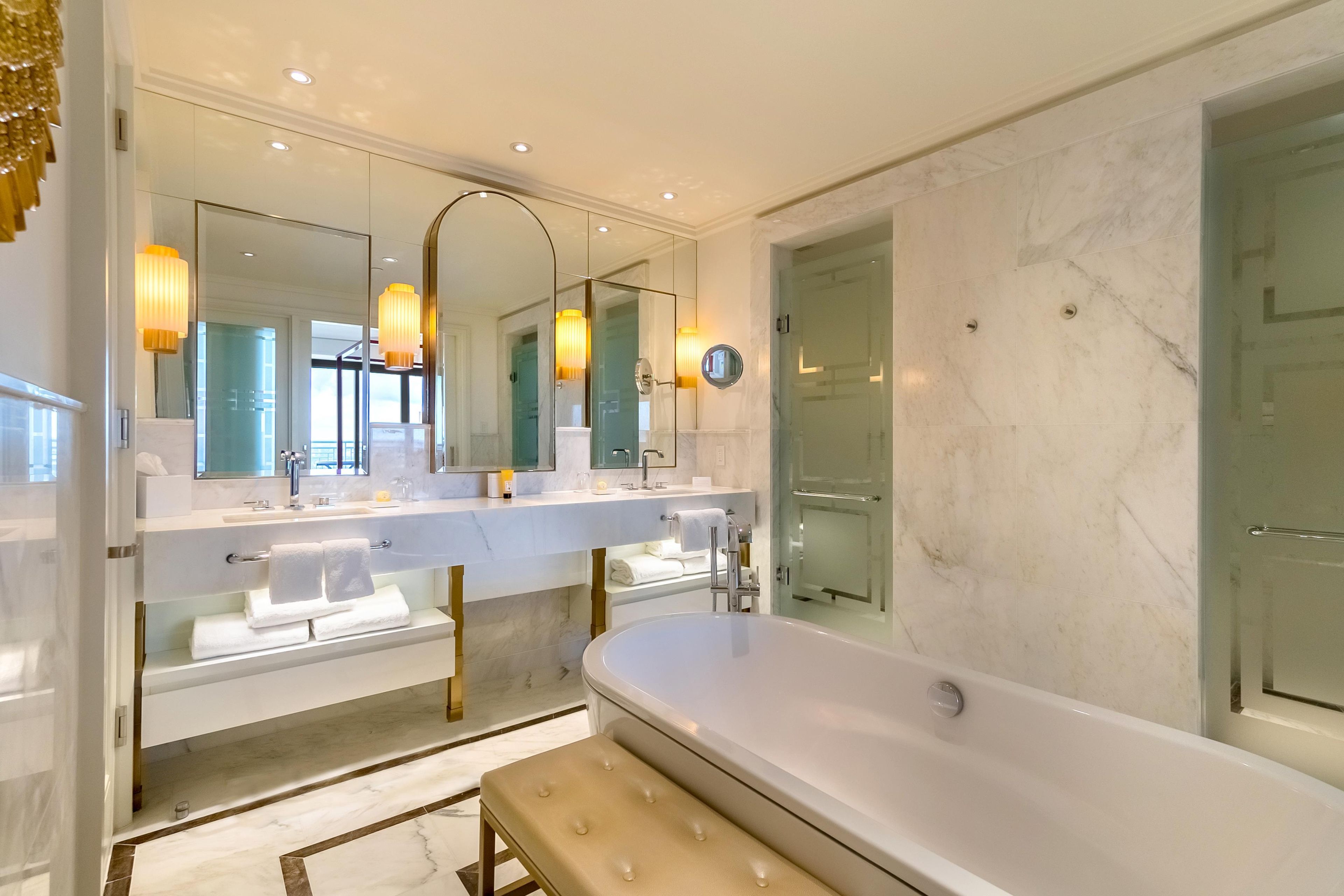 Ein modernes Badezimmer mit einer großzügigen Badewanne, zwei Waschbecken und einer Duschkabine aus Glas.