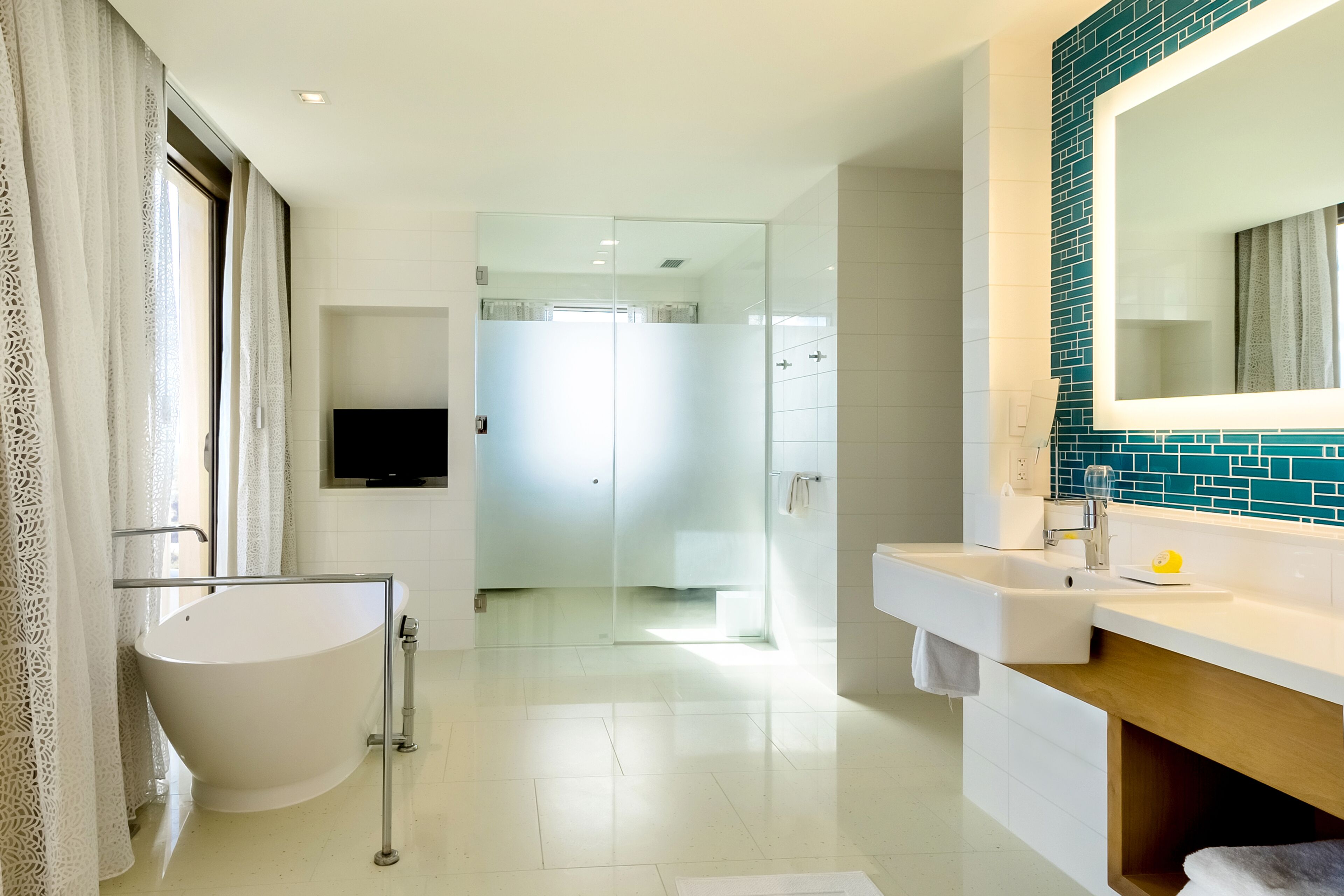 A modern bathroom with a freestanding bathtub, a vanity with a mirror, and a shower area.