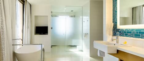 A modern bathroom with a freestanding bathtub, a vanity with a mirror, and a shower area.