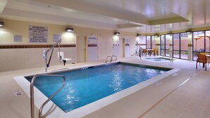 Une piscine intérieure dotée de panneaux d’information clairs concernant les consignes de sécurité, d’un poste de surveillance pour le sauveteur et d’un espace aménagé au bord du bassin avec des chaises et des parasols.