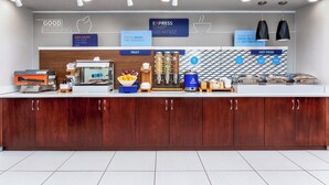 A modern breakfast bar with a wooden counter, a coffee machine, and various food items. - Holiday Inn Express & Suites Lantana by IHG (Lantana)