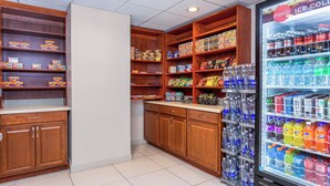 A snack and drink vending area with various packaged snacks and a refrigerated drink dispenser.
